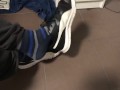 Male shoeplay in striped socks and different sneakers and watching a movie