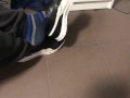 Male shoeplay in striped socks and different sneakers and watching a movie