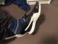 Male shoeplay in striped socks and different sneakers and watching a movie
