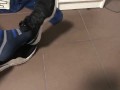 Male shoeplay in striped socks and different sneakers and watching a movie