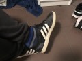 Male shoeplay in striped socks and different sneakers and watching a movie
