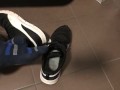 Male shoeplay in striped socks and different sneakers and watching a movie