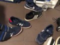 Male shoeplay in striped socks and different sneakers and watching a movie