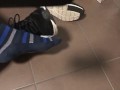 Male shoeplay in striped socks and different sneakers and watching a movie