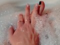 Hot blonde massaging her wet soapy feet in the bath