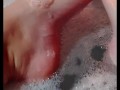 Hot blonde massaging her wet soapy feet in the bath