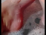 Hot blonde massaging her wet soapy feet in the bath
