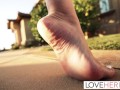 Her bare feet are especially eye-catching as she walks on the pavement, even with the hem of her pants covering parts of them