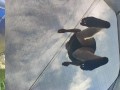 Tall girl in shorts jumping barefooted on a trampoline (slowed down) bottom view