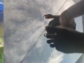 Tall girl in shorts jumping barefooted on a trampoline (slowed down) bottom view