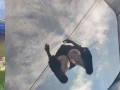 Tall girl in shorts jumping barefooted on a trampoline (slowed down) bottom view