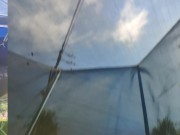 Tall girl in shorts jumping barefooted on a trampoline (slowed down) bottom view