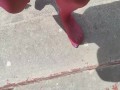 Walking around barefoot wearing red nylon stockings