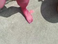 Walking around barefoot wearing red nylon stockings