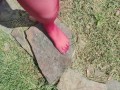 Walking around barefoot wearing red nylon stockings