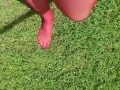 Walking around barefoot wearing red nylon stockings