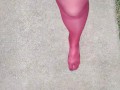 Walking around barefoot wearing red nylon stockings