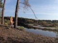 Naked girl walks along the river and forest