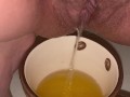 Girl pisses in a coffee cup