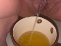 Girl pisses in a coffee cup
