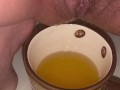 Girl pisses in a coffee cup
