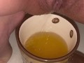 Girl pisses in a coffee cup
