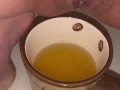 Girl pisses in a coffee cup