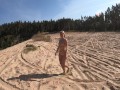 Nude girl walks in a sand quarry