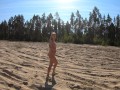 Nude girl walks in a sand quarry