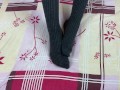 Girl in gray long socks on her legs caresses herself in bed