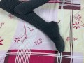 Girl in gray long socks on her legs caresses herself in bed
