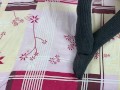 Girl in gray long socks on her legs caresses herself in bed