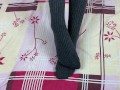 Girl in gray long socks on her legs caresses herself in bed
