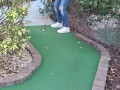 Small petite girl playing golf and not doing good at it