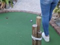 Small petite girl playing golf and not doing good at it