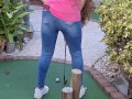 Small petite girl playing golf and not doing good at it