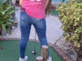 Small petite girl playing golf and not doing good at it