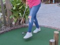 Small petite girl playing golf and not doing good at it