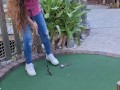 Small petite girl playing golf and not doing good at it