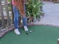 Small petite girl playing golf and not doing good at it