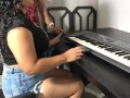 Una joven con curvas y una falda ajustada tomando su primera lección de teclado