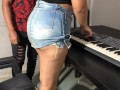 Una joven con curvas y una falda ajustada tomando su primera lección de teclado