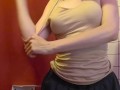 Charming girl takes off her bra from under her T-shirt