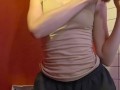 Charming girl takes off her bra from under her T-shirt