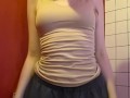 Charming girl takes off her bra from under her T-shirt