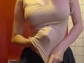 Charming girl takes off her bra from under her T-shirt