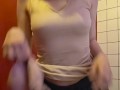 Charming girl takes off her bra from under her T-shirt