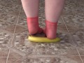 Fat legs in socks ruthlessly trample banana. Crush Fetish, foot fetish.