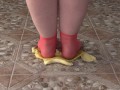 Fat legs in socks ruthlessly trample banana. Crush Fetish, foot fetish.