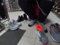 Foot fetish in a public shoe store. Fat legs try on sneakers.